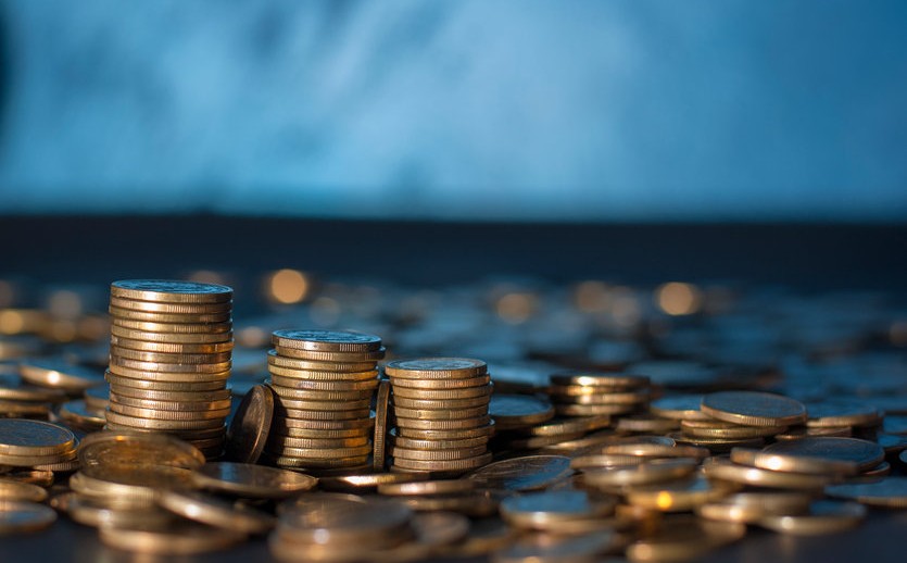 Banking and money trading. Golden metal coins stacked in different combinations on dark blue blurred background. Serbian metal coin, copy space