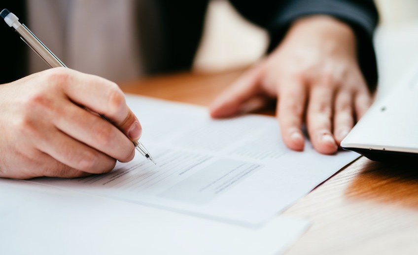 Businessman filling document, signing contract