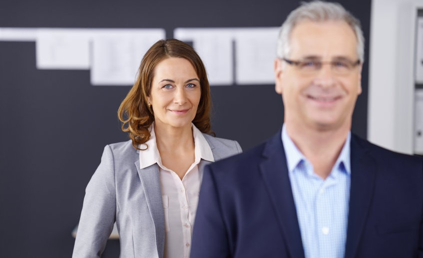 Business woman standing behind co-worker